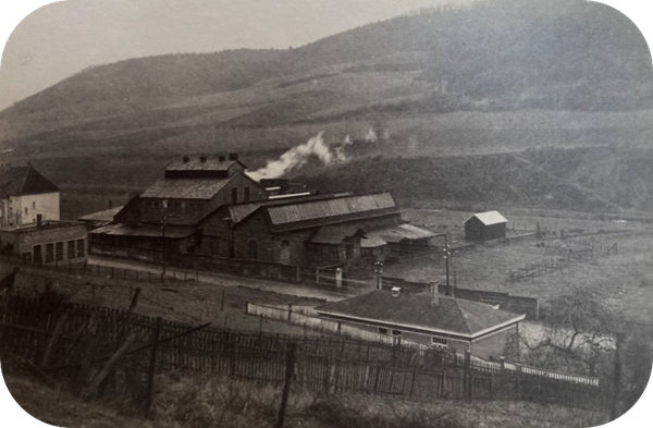 Black-and-white photograph of the old factory buildings – depiction of the merger of the Wiesenthal and Oesterau plants to form “Brockhaus Söhne oHG.”